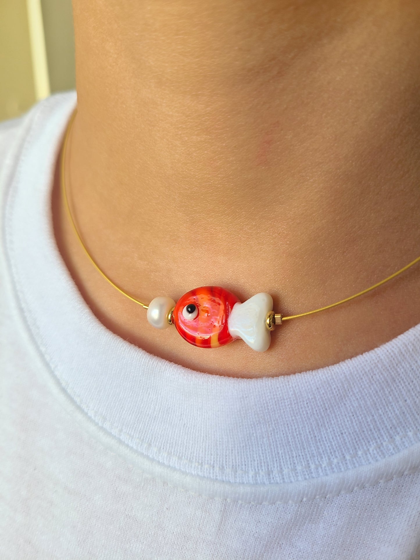 Collar con pez rojo y blanco.